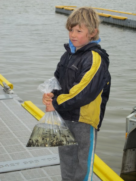 Young lad with a demo bag of fingerlings