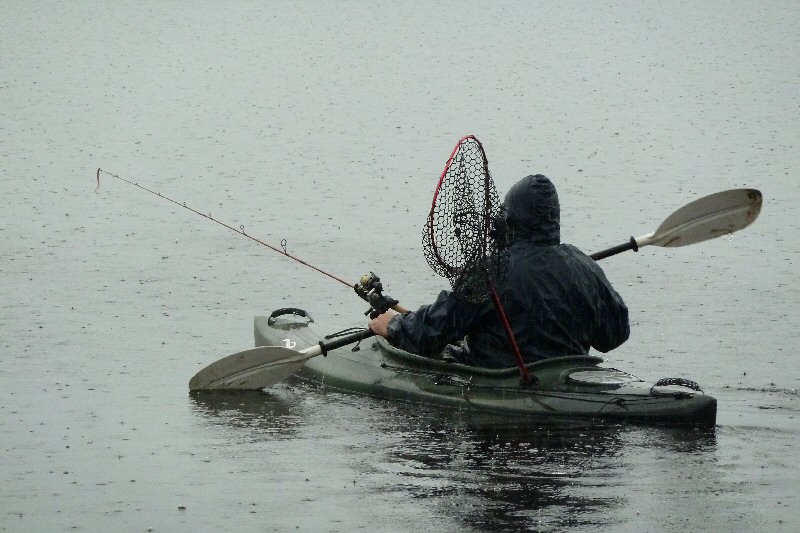 Fishing from a canoe in the rain Lake Tyers Beach