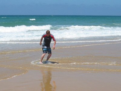 Skimboarding in the surf at Lake Tyers Beach